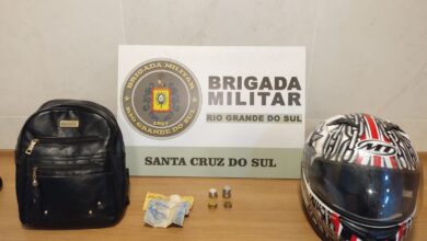 Mesa com placa da brigada militar no fundo e com capacete em cima